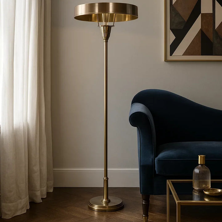 Eingeschalteter Art-Déco-Deckenfluter in poliertem Antikmessing neben nachtblauem Samt-Chaiselongue und Glasbeistelltisch