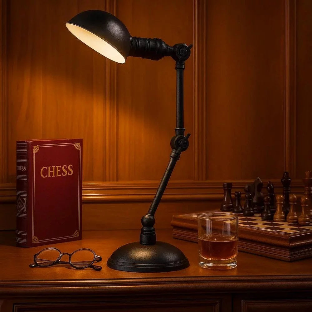 Vintage Gelenkarm-Tischleuchte in Antikschwarz leuchtet über Schachtisch mit Schachbuch, Brille und Whiskyglas