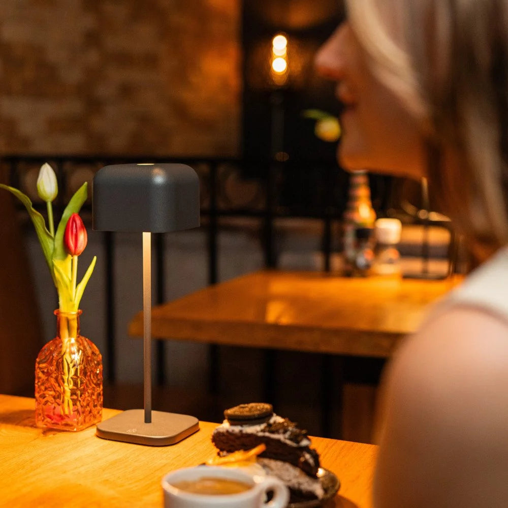 Beleuchteter Restauranttisch mit der dunkelgrauen Akku Tischlampe 