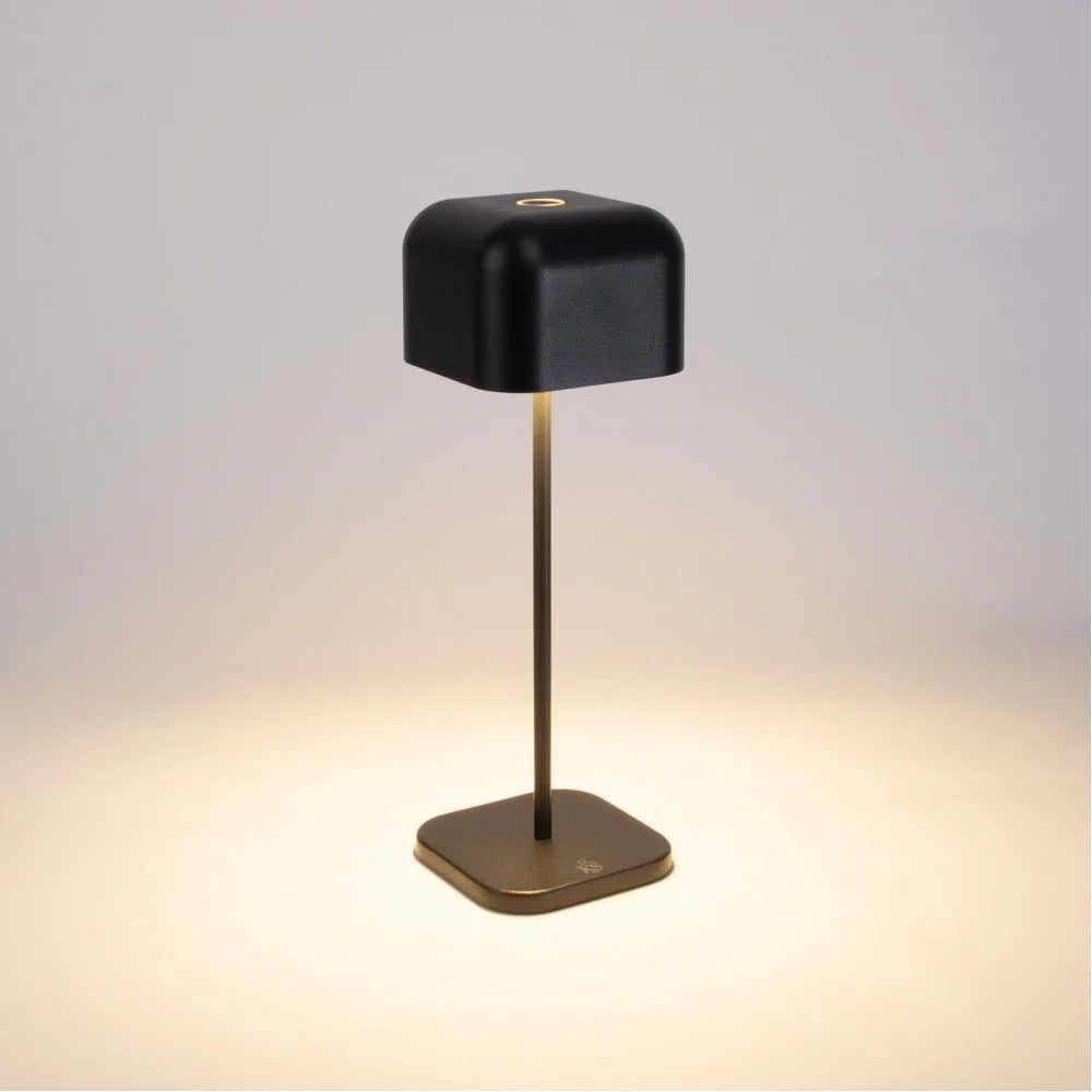 Dunkelgraue Akku Tischlampe eingeschaltet mit Touch-Sensor oben und warmem Lichtschein auf dem Sockel