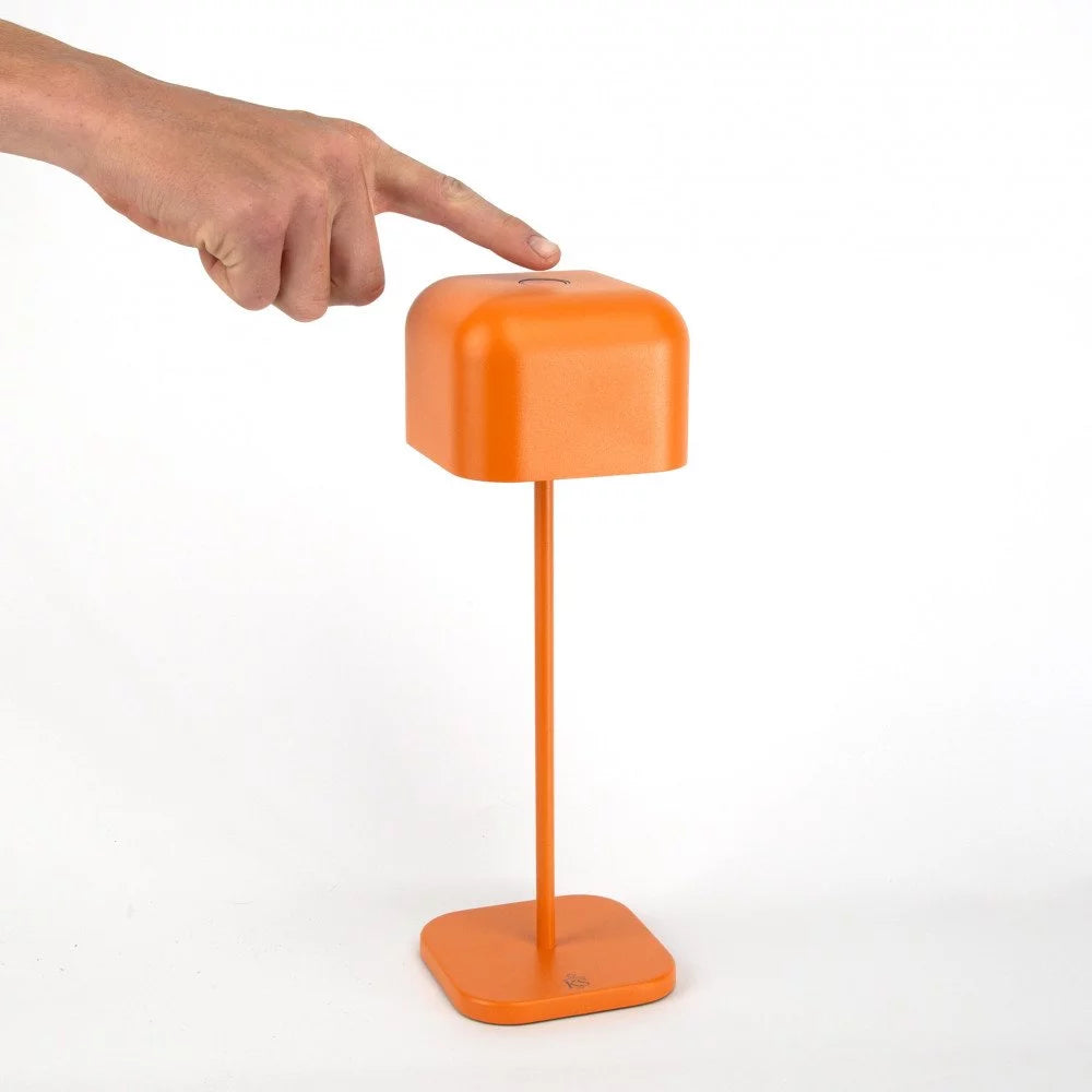 Mann drückt Einschaltknopf kabellose Tischlampe Cabo Matt Orange – einfaches Ein- und Ausschalten