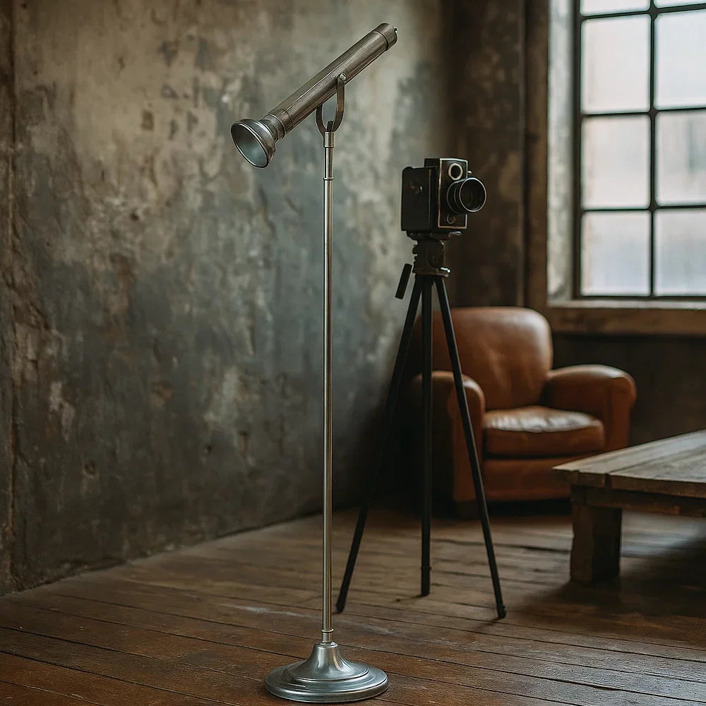 Industrielle Stehlampe in Antiksilber im Design einer historischen Stabtaschenlampe neben Vintage-Mittelformatkamera auf Stativ im Fotostudio-Loft